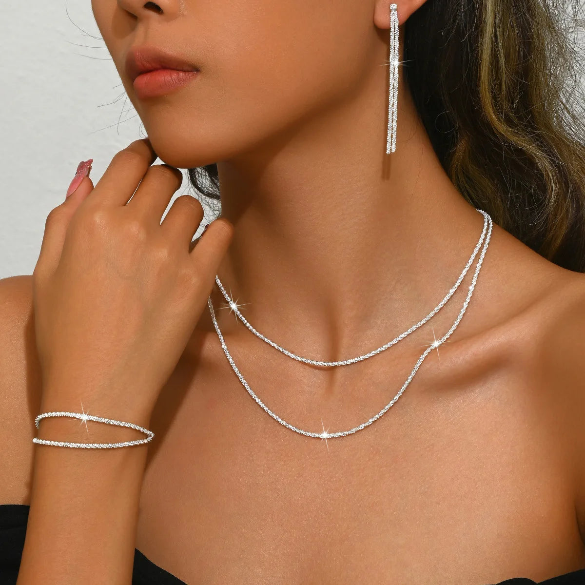 Ensemble de bijoux en chaîne plaquée argent brillante comprenant un collier ras du cou et un bracelet.