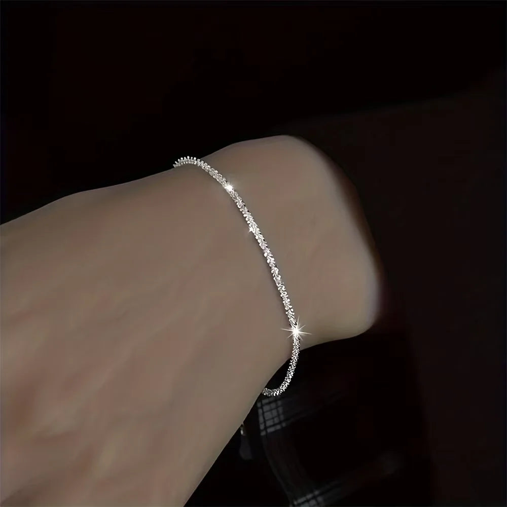 Ensemble de bijoux en chaîne plaquée argent brillante comprenant un collier ras du cou et un bracelet.