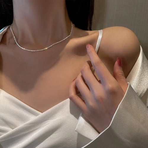 Ensemble de bijoux en chaîne plaquée argent brillante comprenant un collier ras du cou et un bracelet.